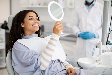 woman at the dentist smiling in mirror
